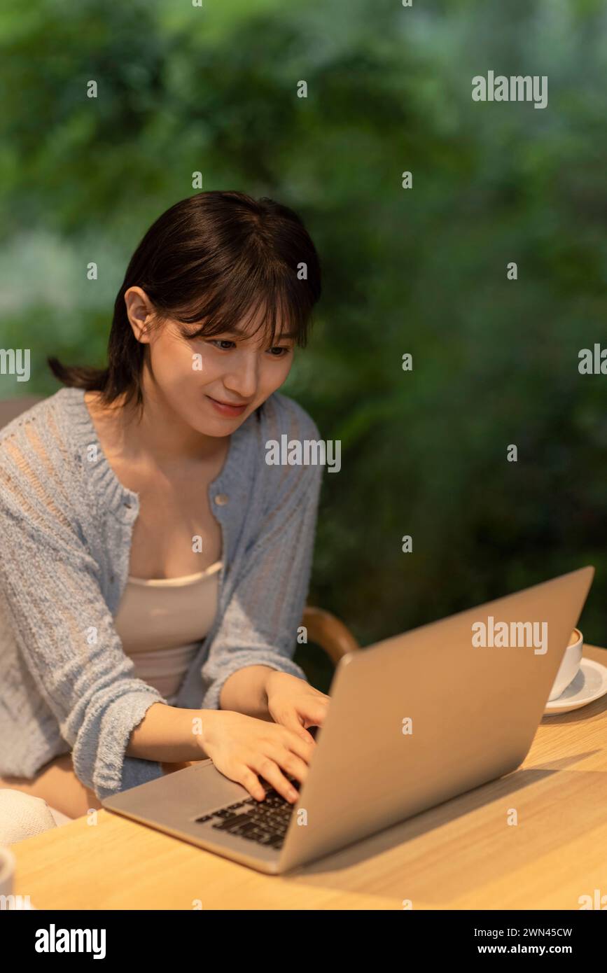 Young woman using laptop in café Stock Photo