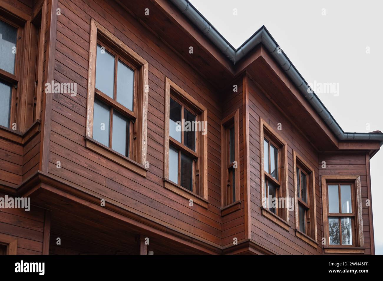 House made of laminated veneer lumber. Cottage made of laminated wood. Houses made of wood. Top of a wooden house and windows. House building made by Stock Photo