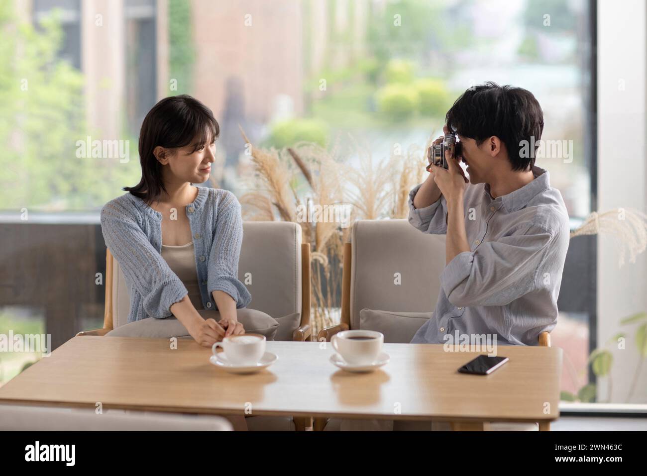 Young couple taking photos in café Stock Photo