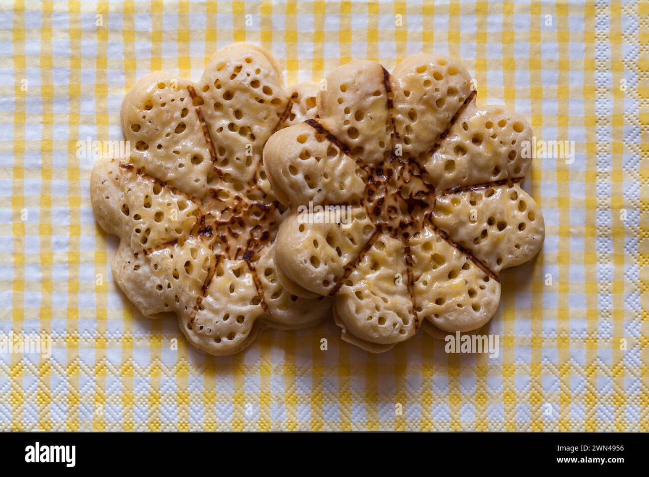 Blooming Lovely Crumpets light fluffy flower shaped crumpets from M&S on yellow and white checked serviette napkin Stock Photo