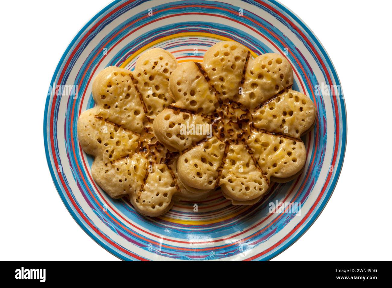 Blooming Lovely Crumpet light fluffy flower shaped crumpet from M&S  on colourful plate, looking down on from above Stock Photo