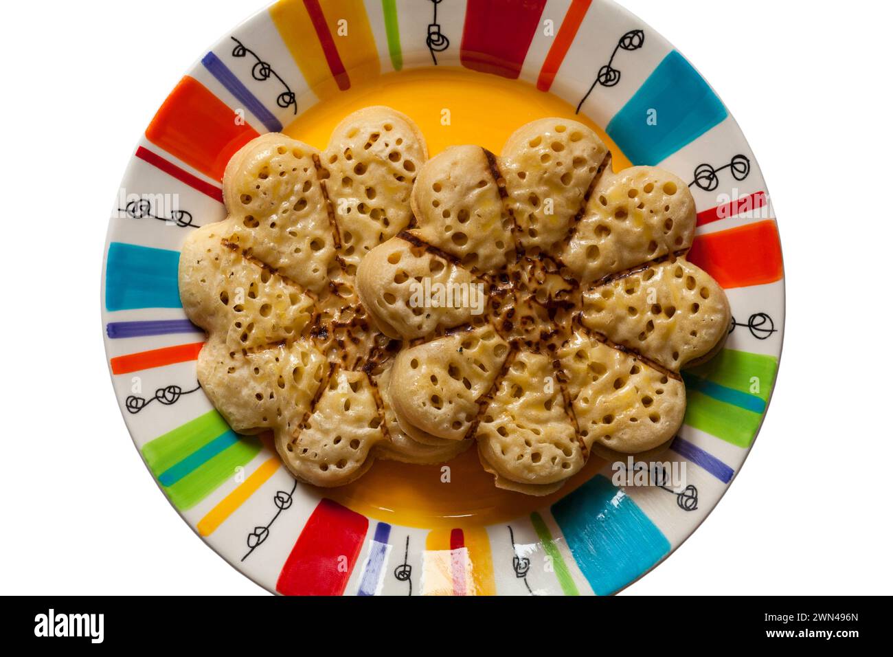 Blooming Lovely Crumpet light fluffy flower shaped crumpet from M&S  on colourful plate, looking down on from above Stock Photo