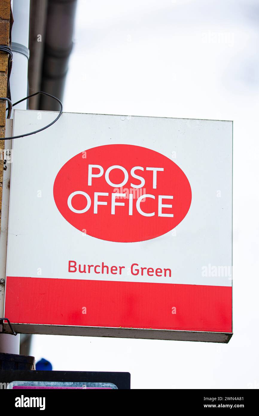Post office sign hanging on the side of an old building. Stock Photo