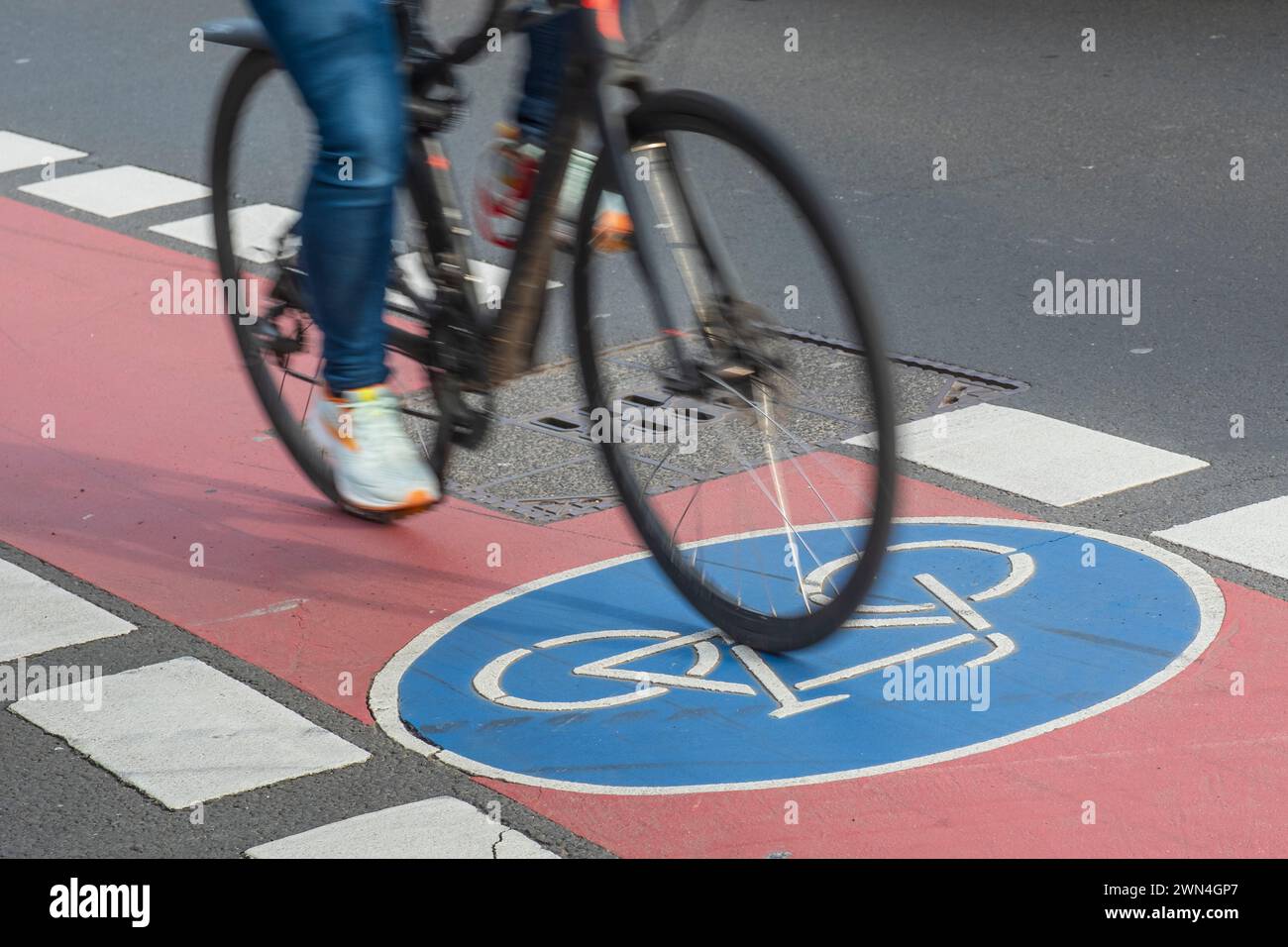 Blurred bicycle on a cycle path with a blue cycle path symbol Stock Photo