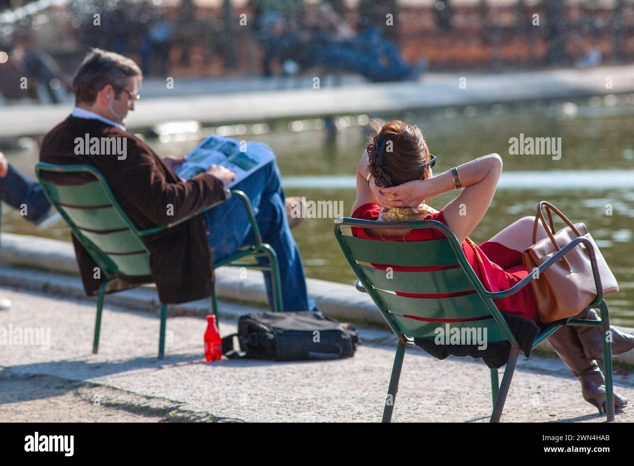 People sitting by the Grand Bassin Rond pond in the Tuileries garden on a summer day in Paris, France. Stock Photo