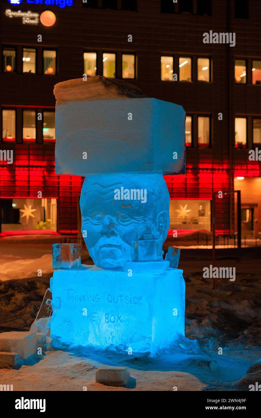 a blue lit ice sculpture titled thinking outside the box features a human head between two blocks of ice in kiruna new city centre in arctic sweden Stock Photo