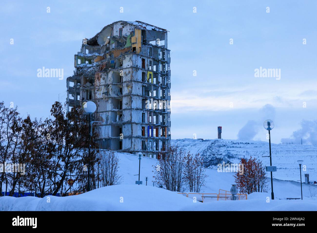 a partially demolished tower block in kiruna old town in front of the snow covered iron ore mine is part of the city relocation Stock Photo