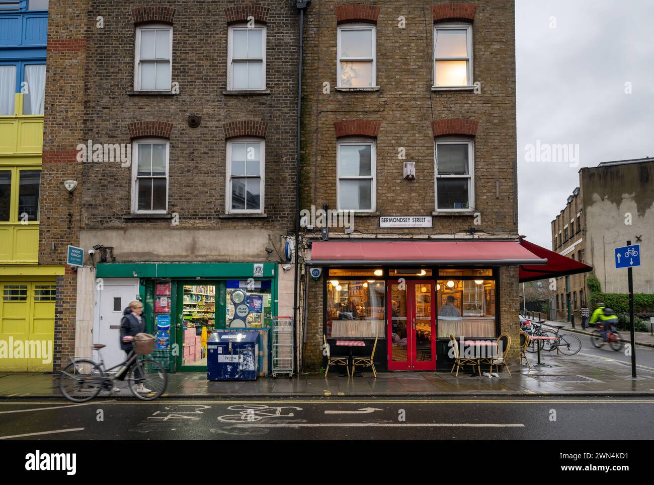 Bermondsey, London, UK: Small shop and restaurants on Bermondsey Street in the London borough of Southwark with two cyclists. Stock Photo