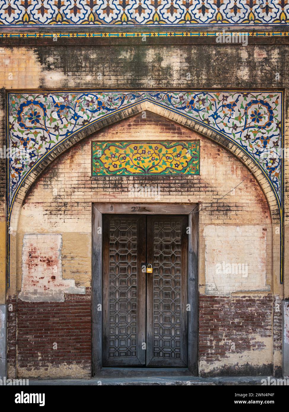 A wooden door at historic landmark Masjid Wazir Khan, a 17th-century Mughal mosque located in the city of Lahore, Punjab, Pakistan. Stock Photo