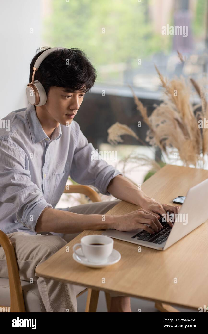 Young man using laptop in café Stock Photo