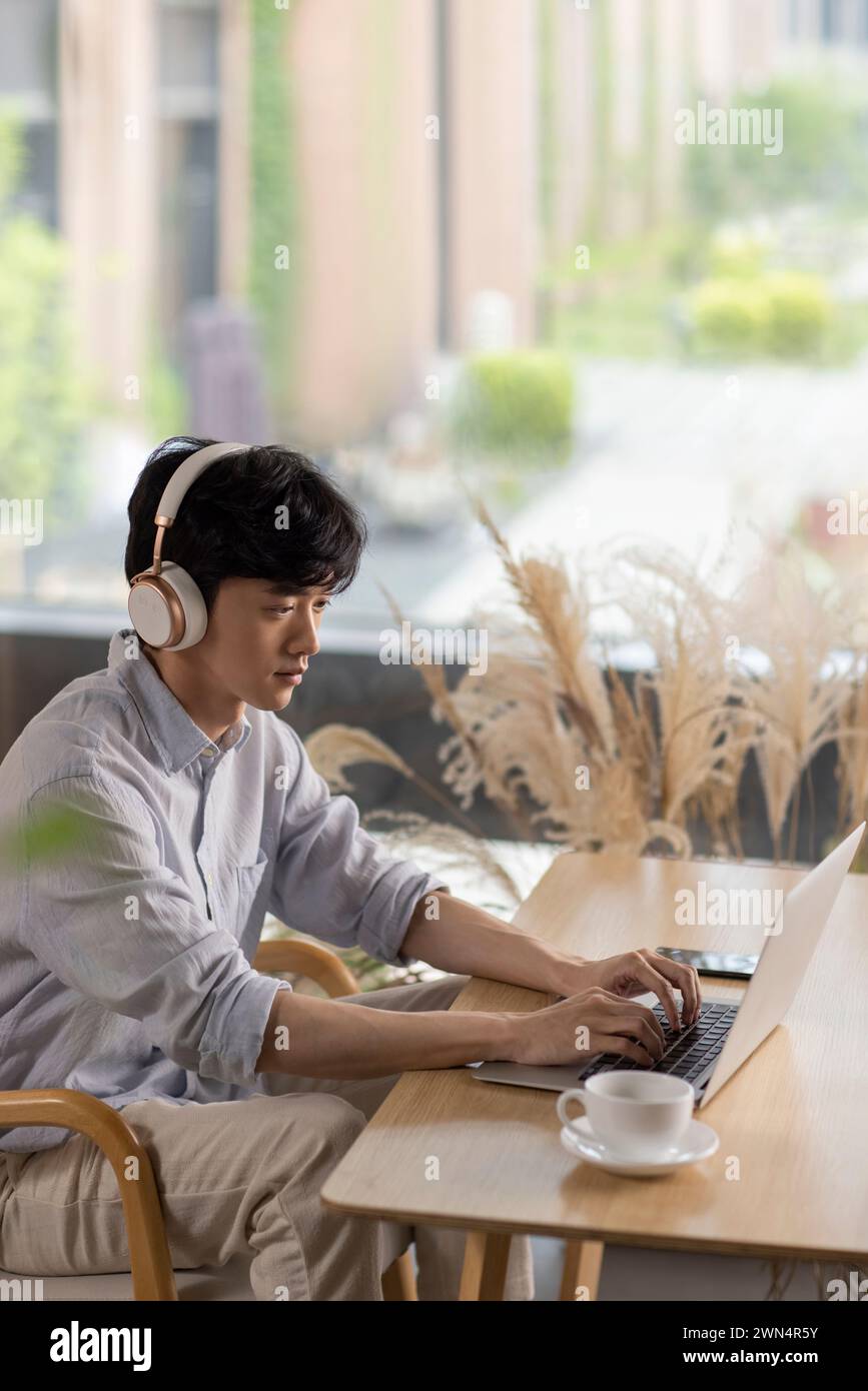 Young man using laptop in café Stock Photo