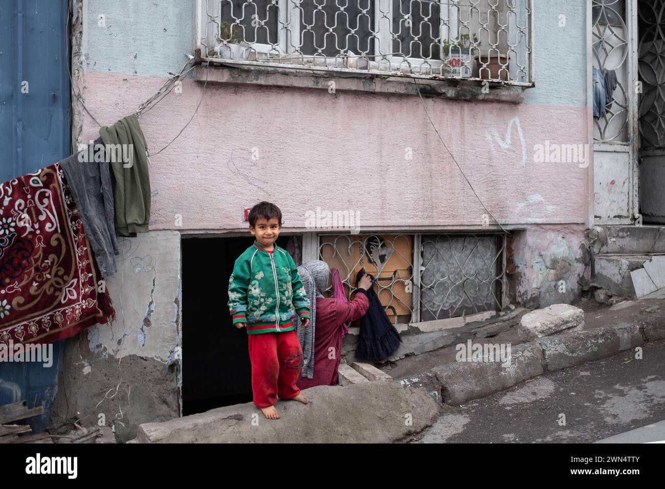 Barefoot small boy standing on the street in the poor neighborhoods of Istanbul Turkey. Unidentified poor children on the street. Poor little child-De Stock Photo