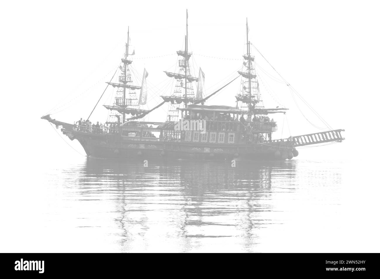 Ghostly voyage. Pirate ship tourist attraction cruising in the misty aegean sea. Stock Photo