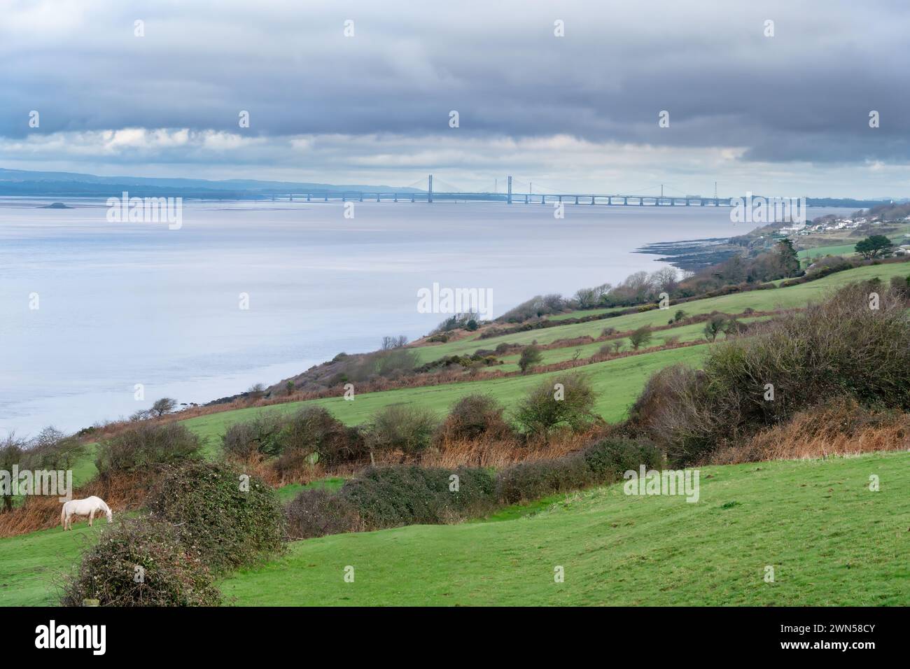 A view across fields back along the Severn River Estuary from Clevedon, towards the Prince of Wales Bridge crossing from England to Wales Stock Photo