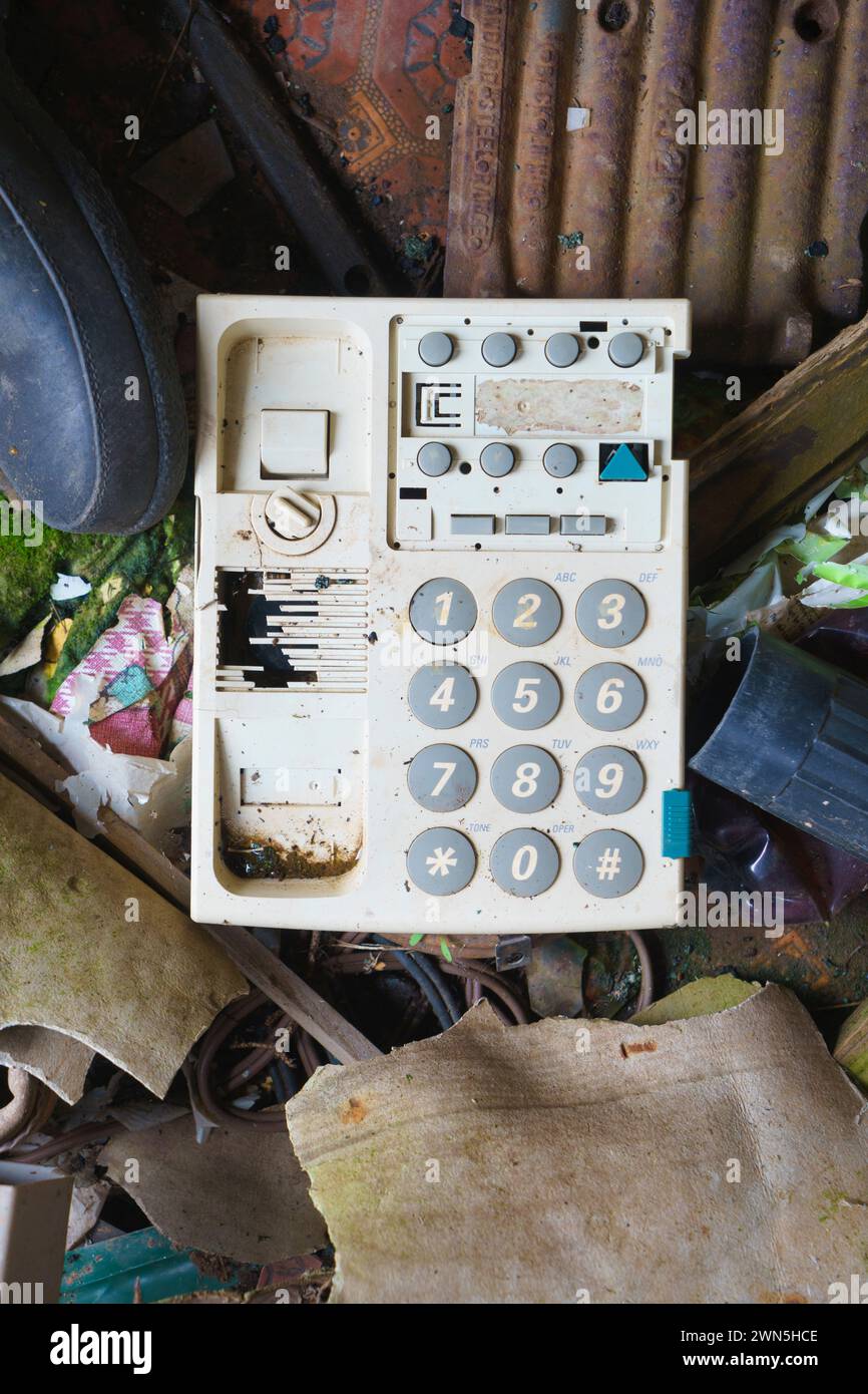 Old touch tone phone left on the floor of a derelict abandoned house. Stock Photo