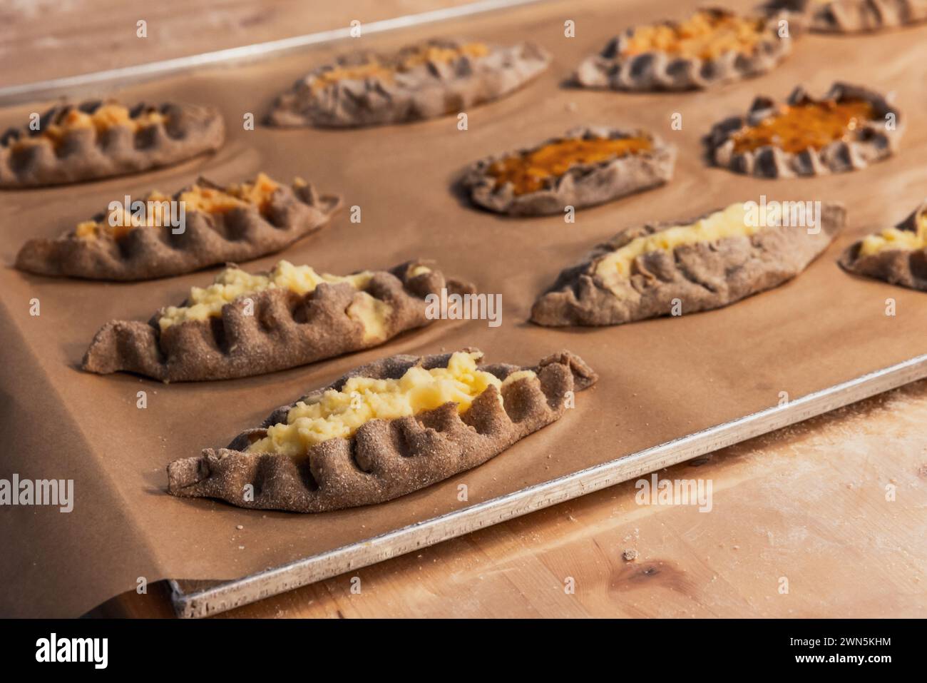 Karelian pasties with mashed potato and carrot filling just after backing, close-up photo with selective soft focus Stock Photo