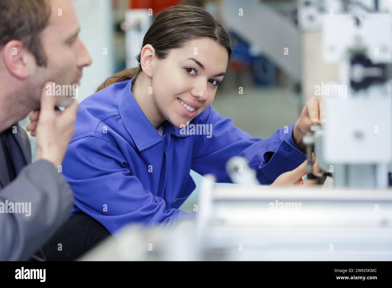 happy female worker in a metal workshop Stock Photo