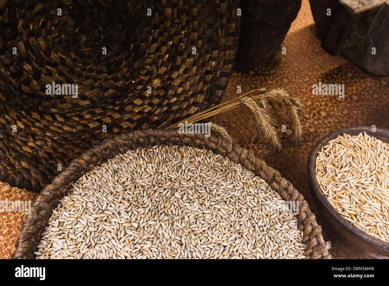 Rye grains lie in a basket and clay bowl. Secale cereale Stock Photo
