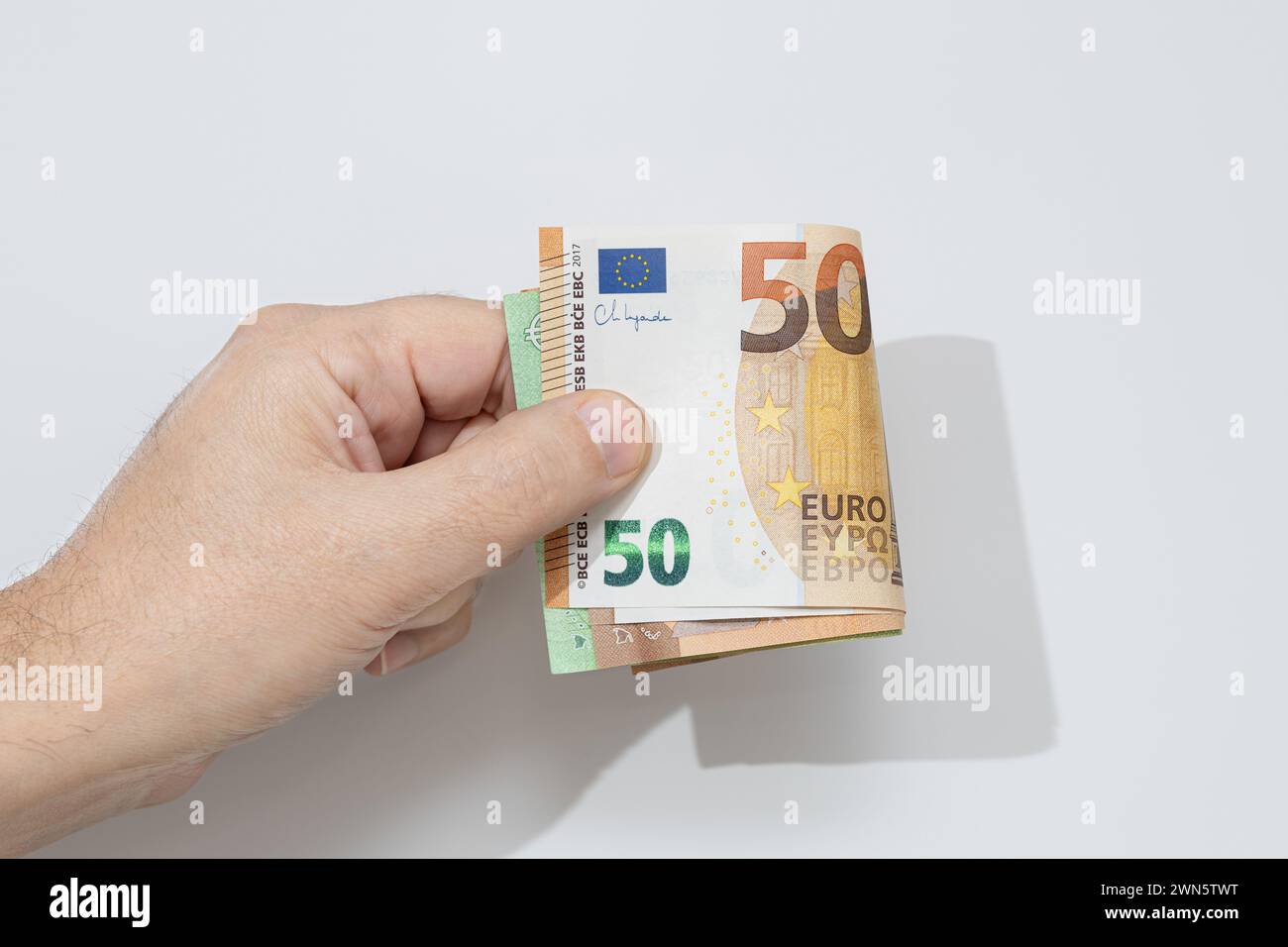 Hand holding many euro banknotes on white background Stock Photo - Alamy