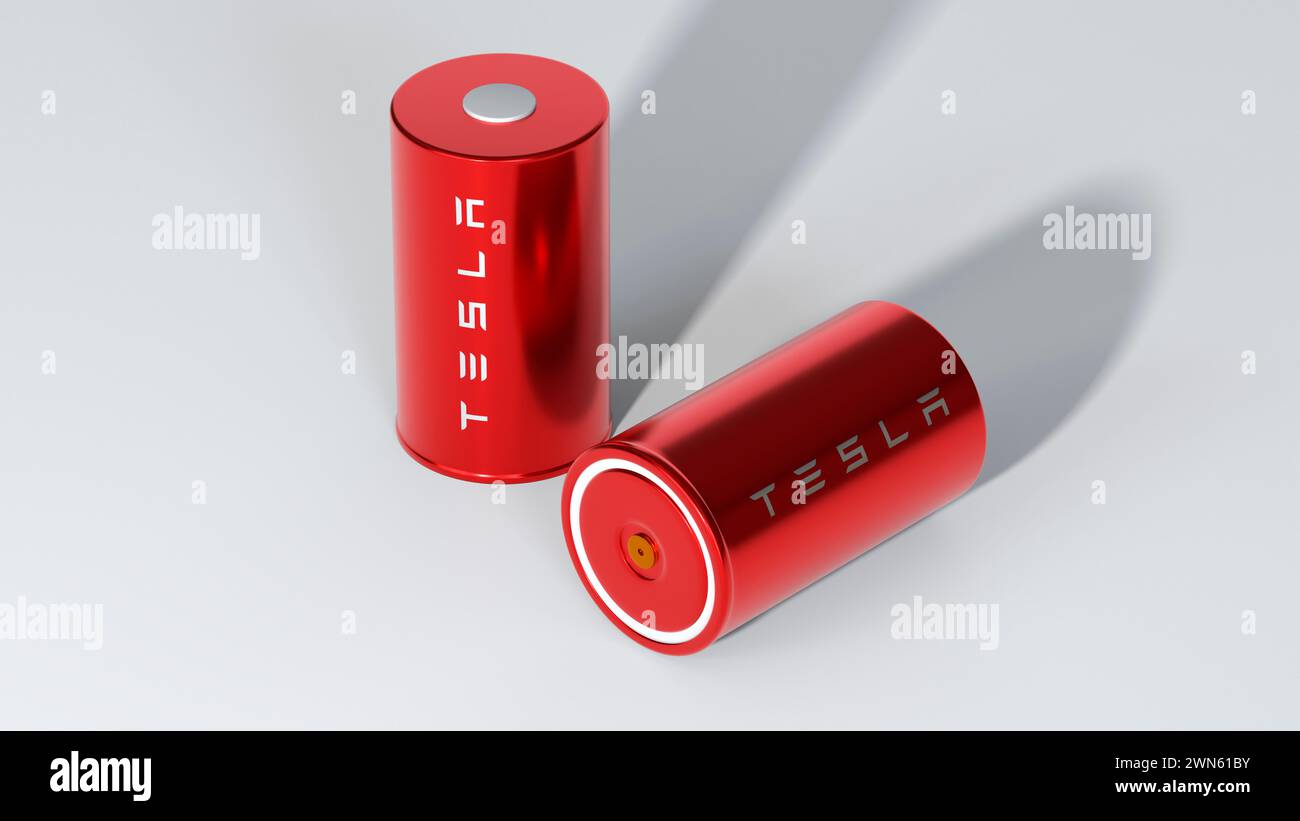 two Lithium-ion red 4680 Tesla battery with logo, one High-capacity accumulator, table cell, Energy Storage, electric vehicle production, High Tech Au Stock Photo