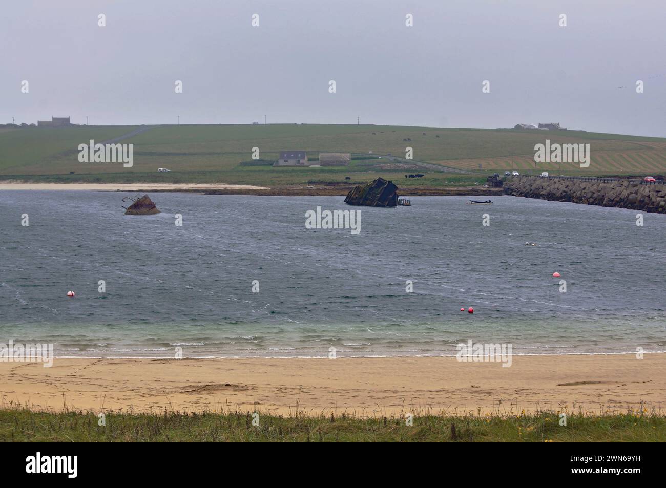WW1 Blockships (sunken vessels) and a WW2 Churchill Barriers  (causeway) used  to protect the Scapa Flow Naval Base anchorage on Orkney, Scotland, UK Stock Photo