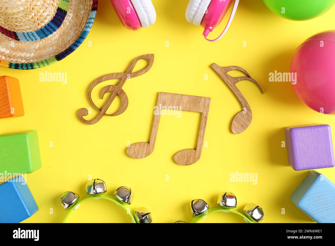 Baby song concept. Wooden notes, tambourines and toys on yellow
