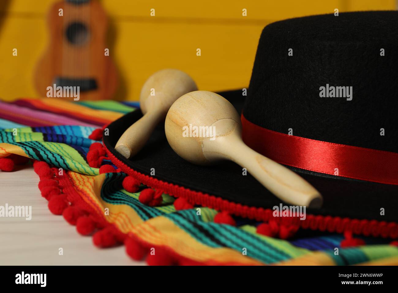 Black Flamenco hat, poncho and maracas on light table, closeup Stock Photo