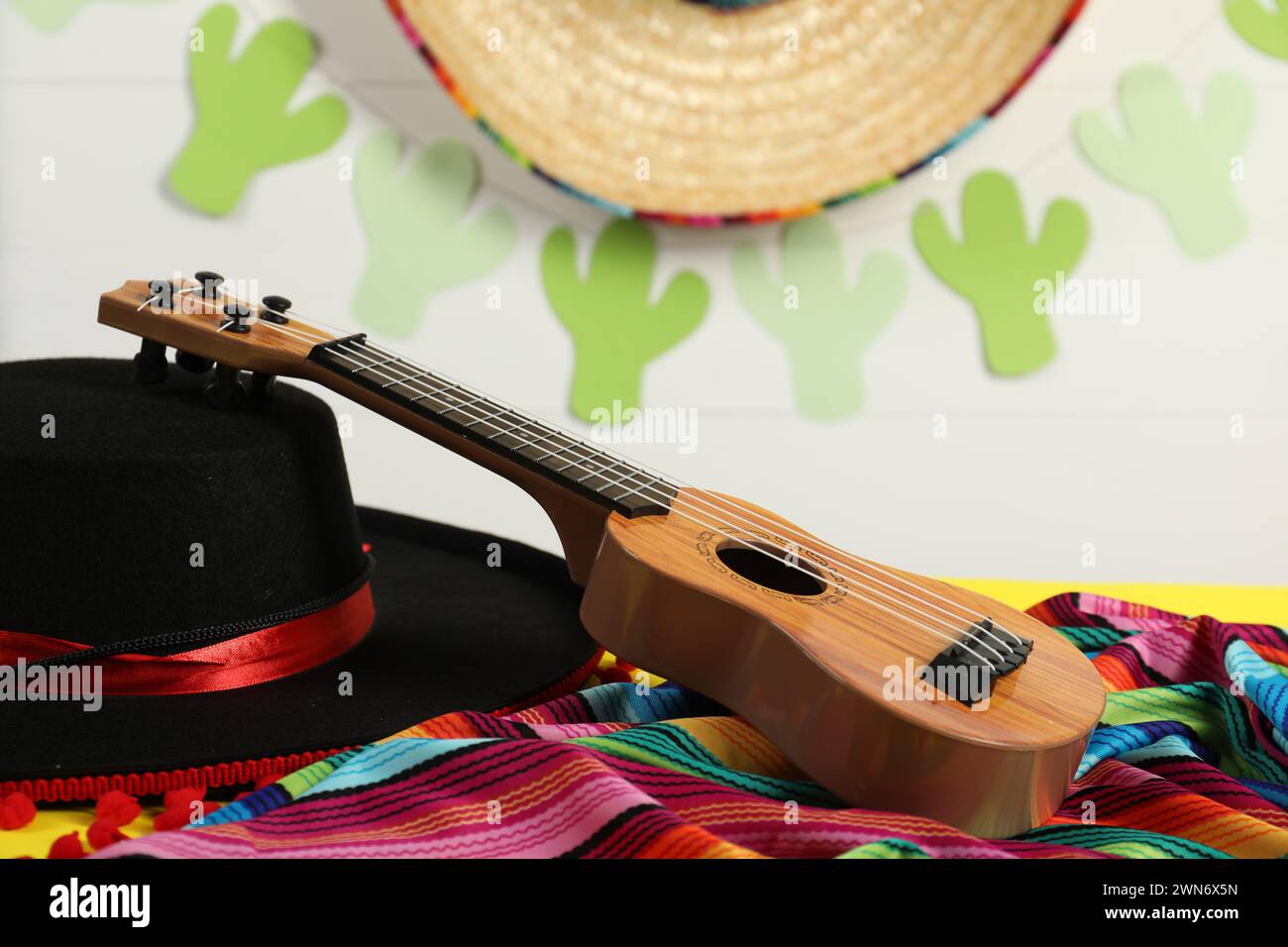 Black Flamenco hat, poncho and ukulele on table, closeup Stock Photo