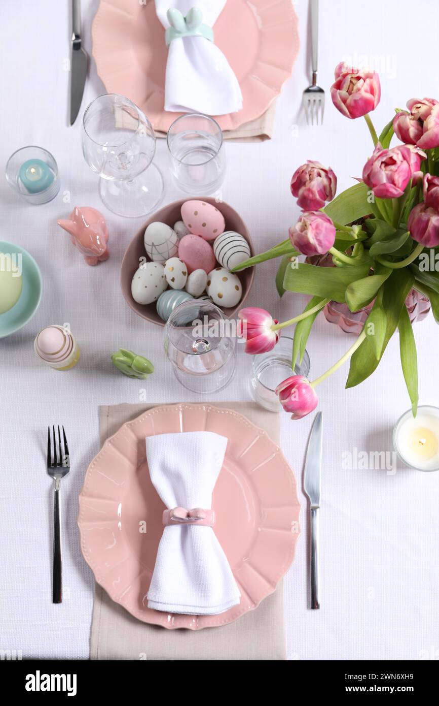 Festive table setting with beautiful flowers, flat lay. Easter celebration Stock Photo