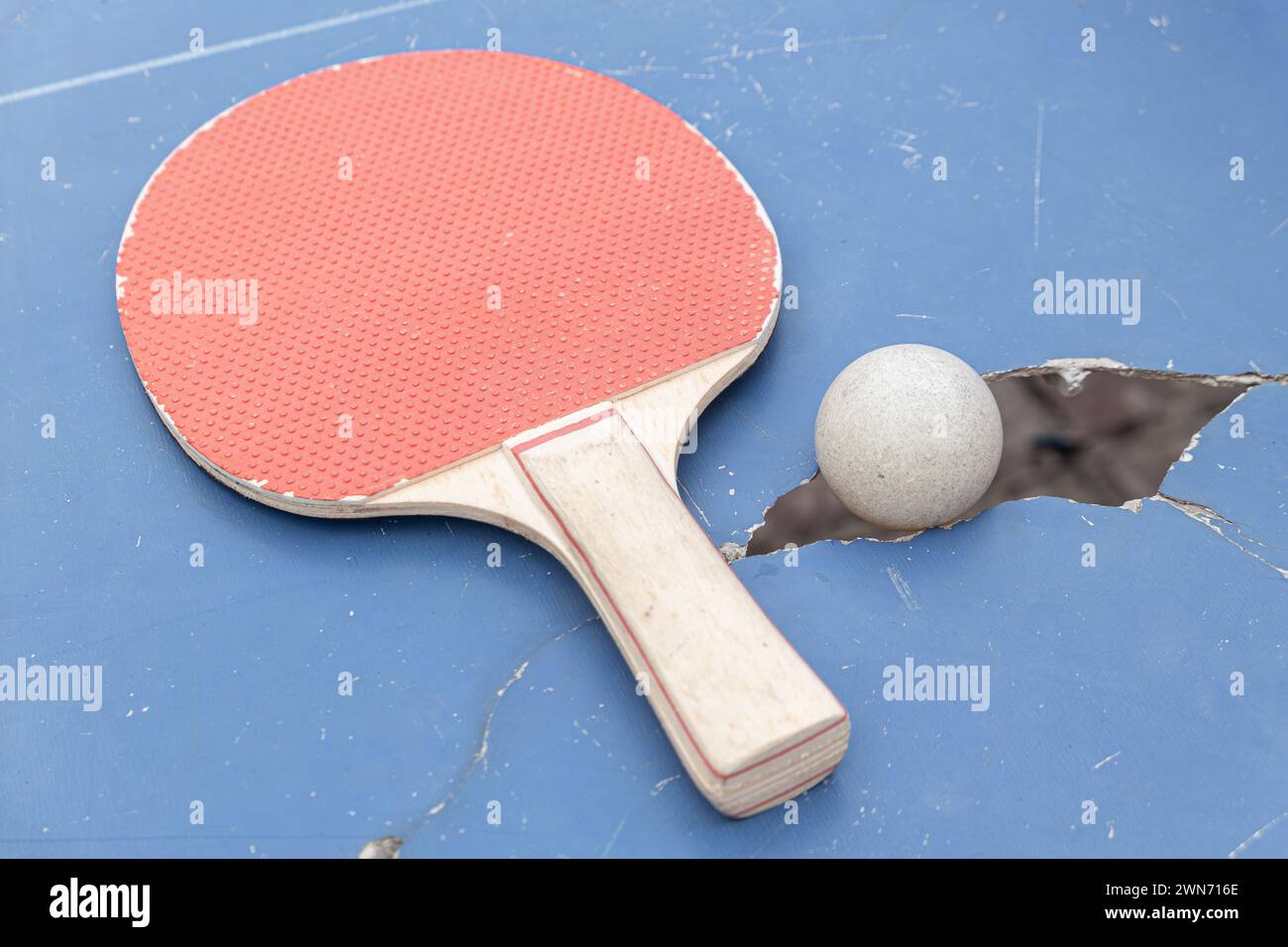 pingpong ball and racket on a damaged table at horizontal composition Stock Photo