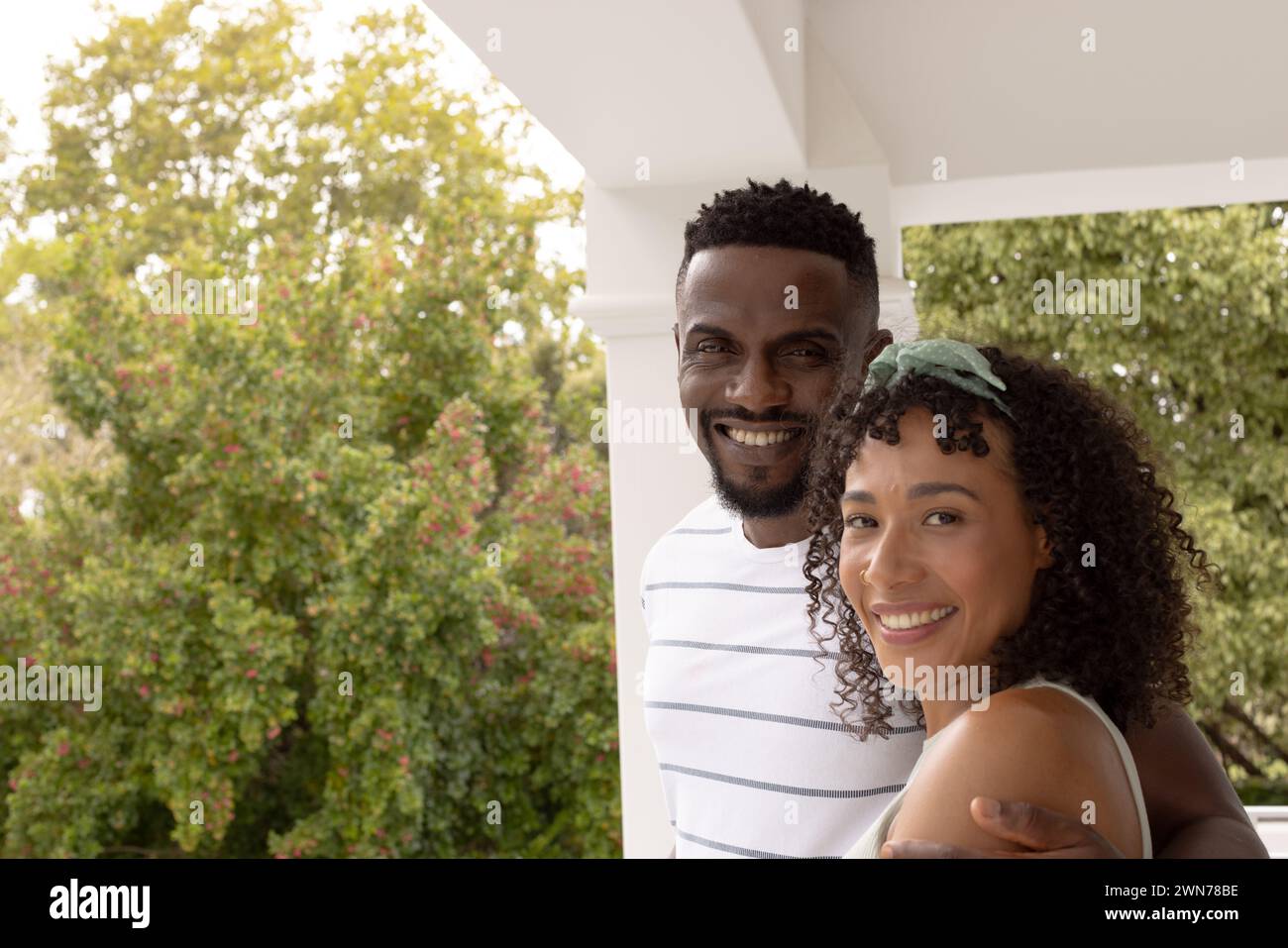 Biracial African American couple share a warm embrace outdoors at home with copy space Stock Photo