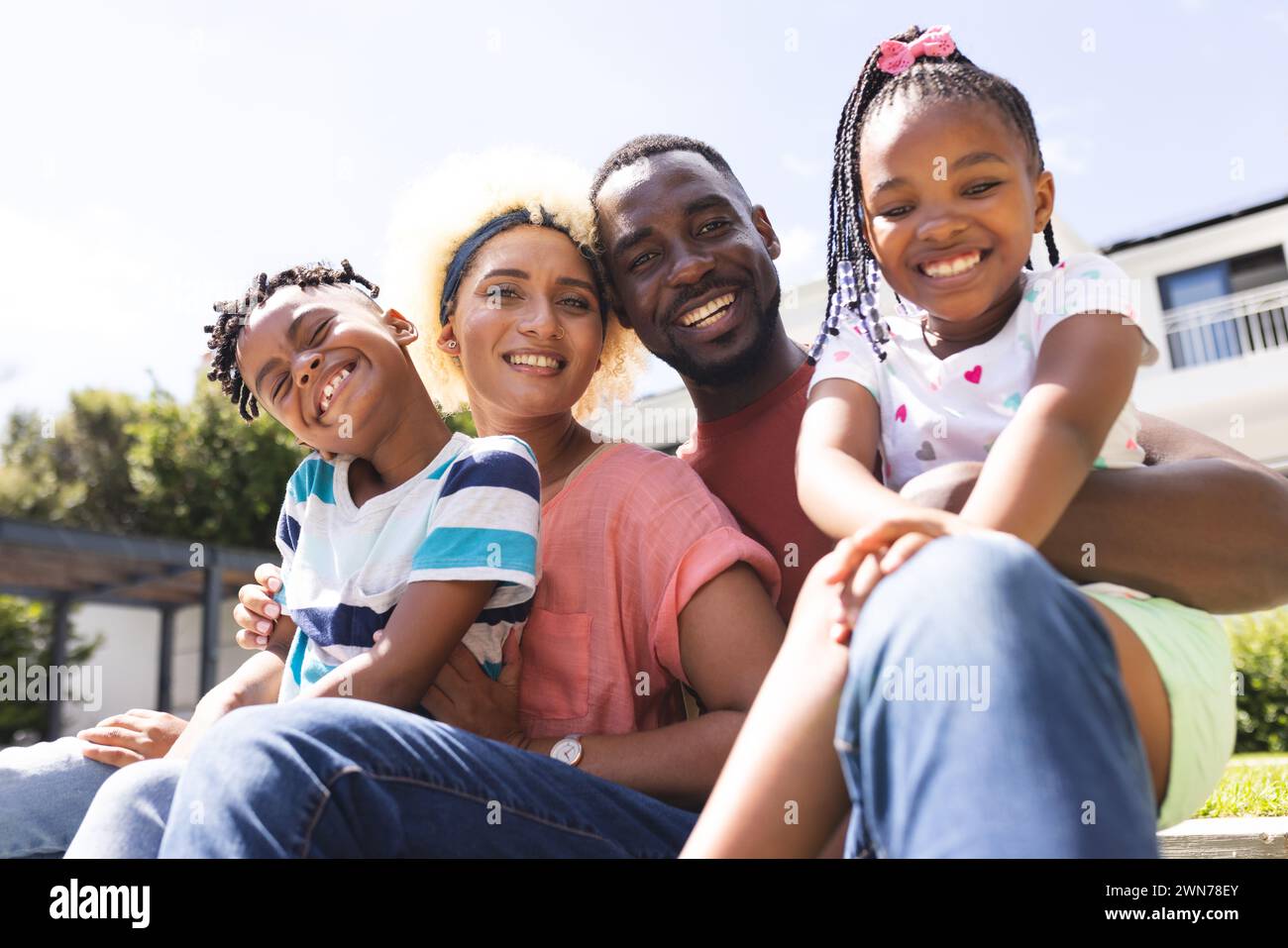 African American father and biracial mother smile with their son and daughter outdoors Stock Photo