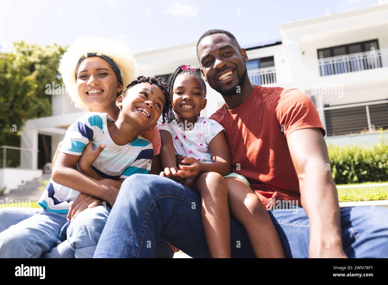African American family with a father, mother, son, and daughter smiling outdoors Stock Photo