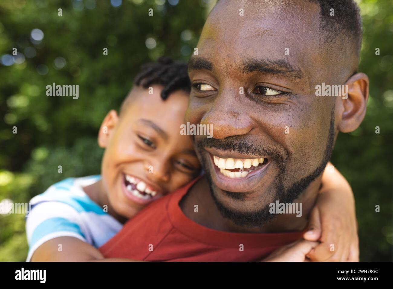 African American father and son share a joyful embrace outdoors Stock Photo