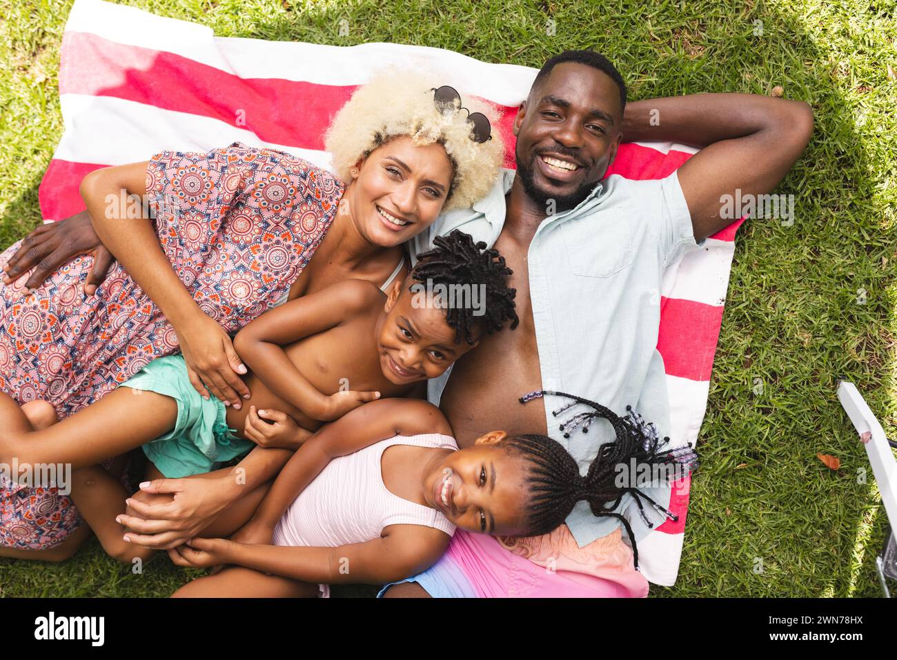 An african american family lies on a blanket with an african american boy and girl Stock Photo