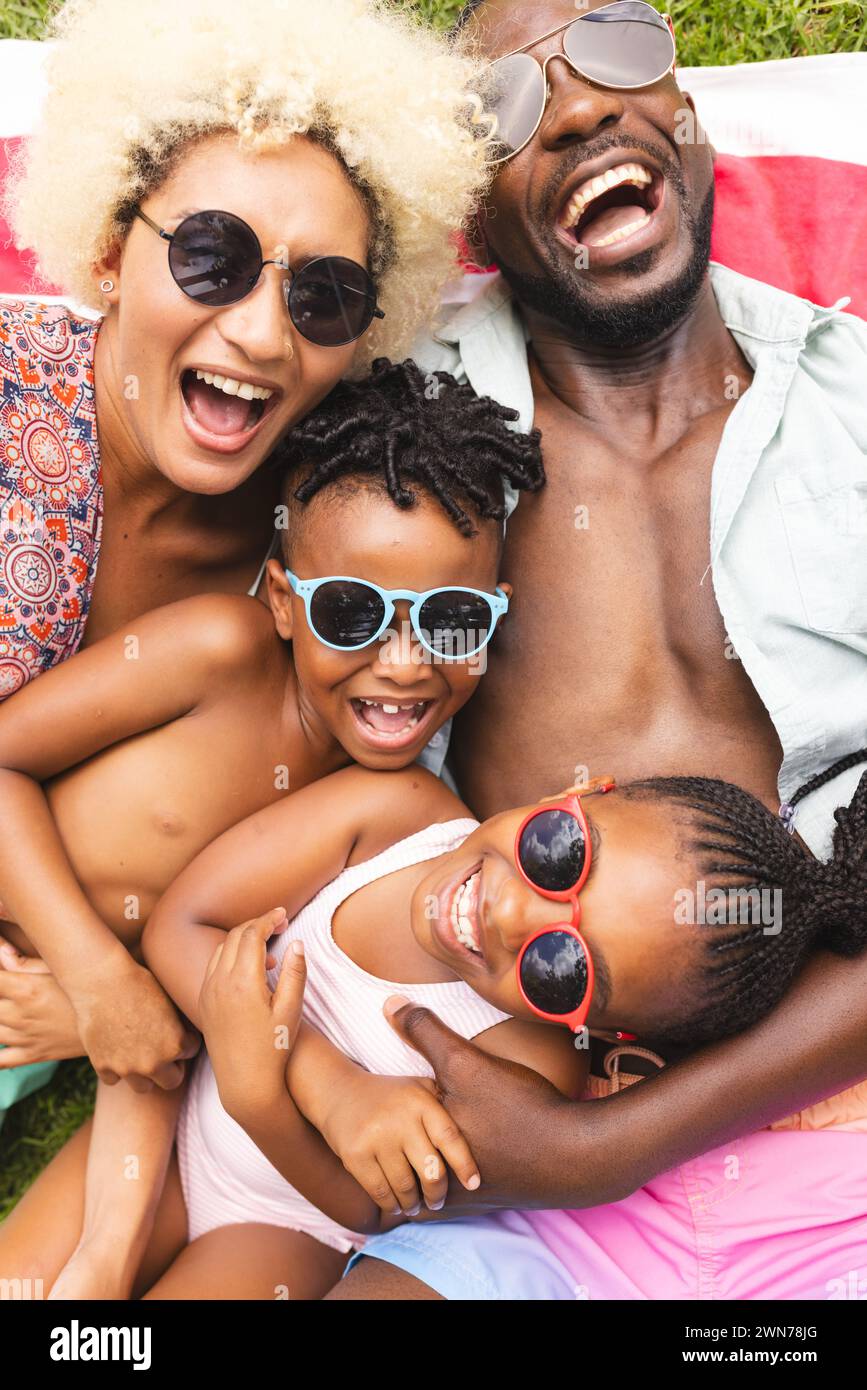 African American family is enjoying a sunny day outdoors, lying on a blanket Stock Photo