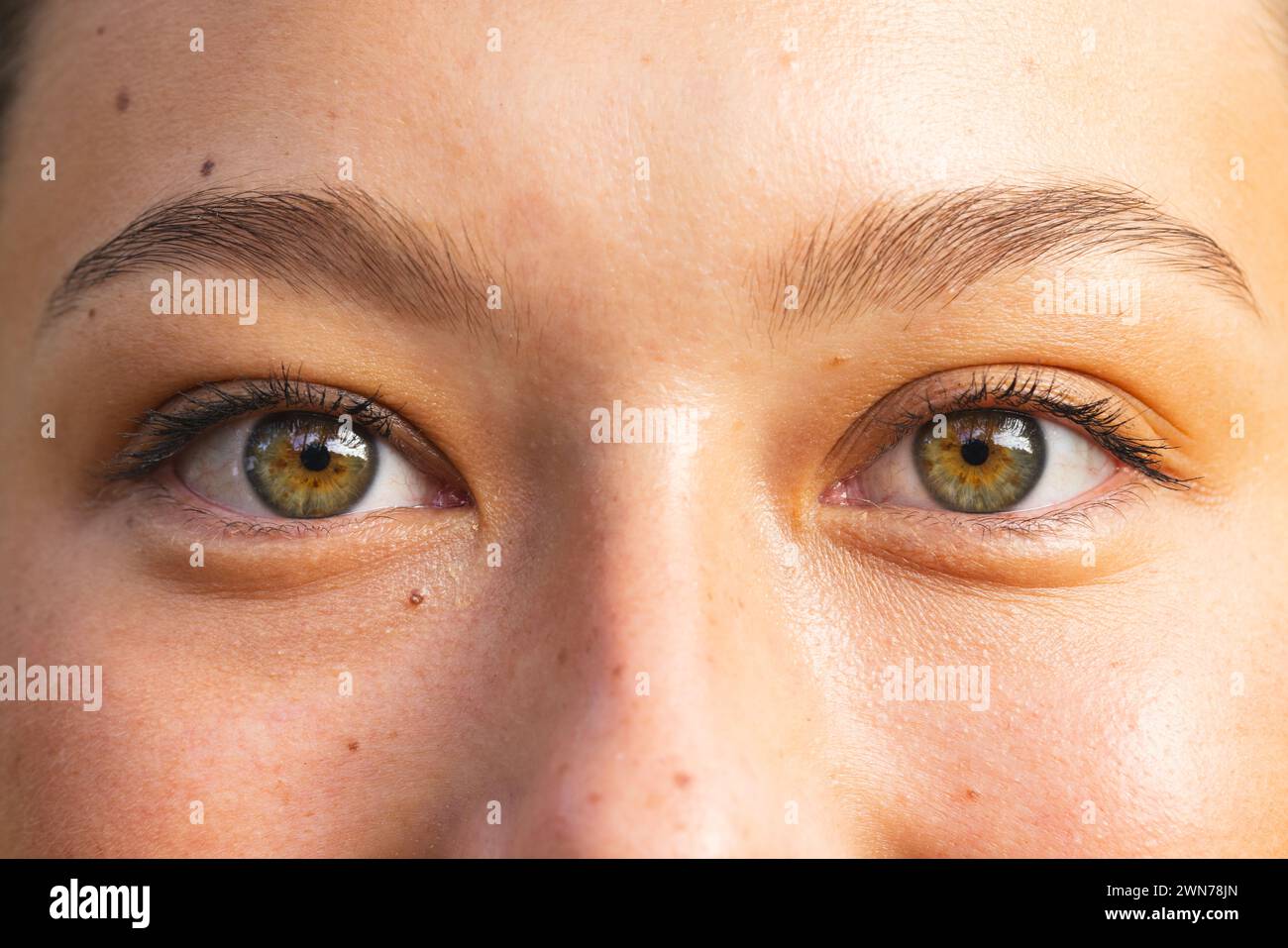 Close-up of a young Caucasian woman's eyes on a hike, showcasing hazel irises Stock Photo