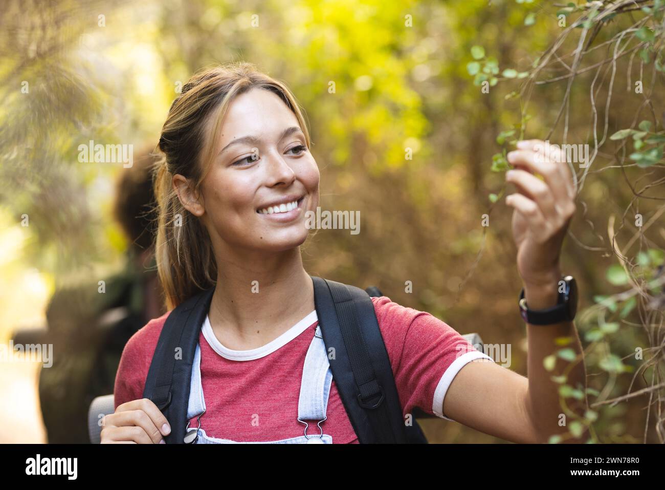 Young biracial woman smiles while hiking in a forest Stock Photo - Alamy