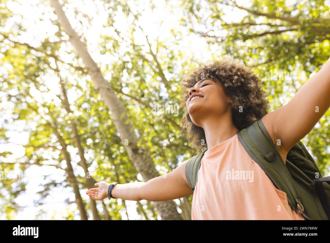 Biracial woman finds joy in nature, symbolizing freedom. Stock Photo