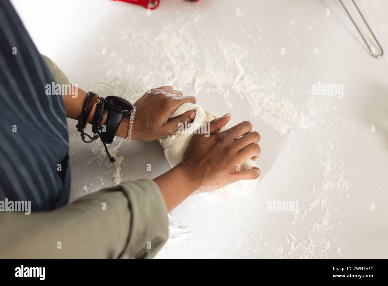 Hands knead dough on a flour-dusted surface with copy space, revealing a baking process Stock Photo