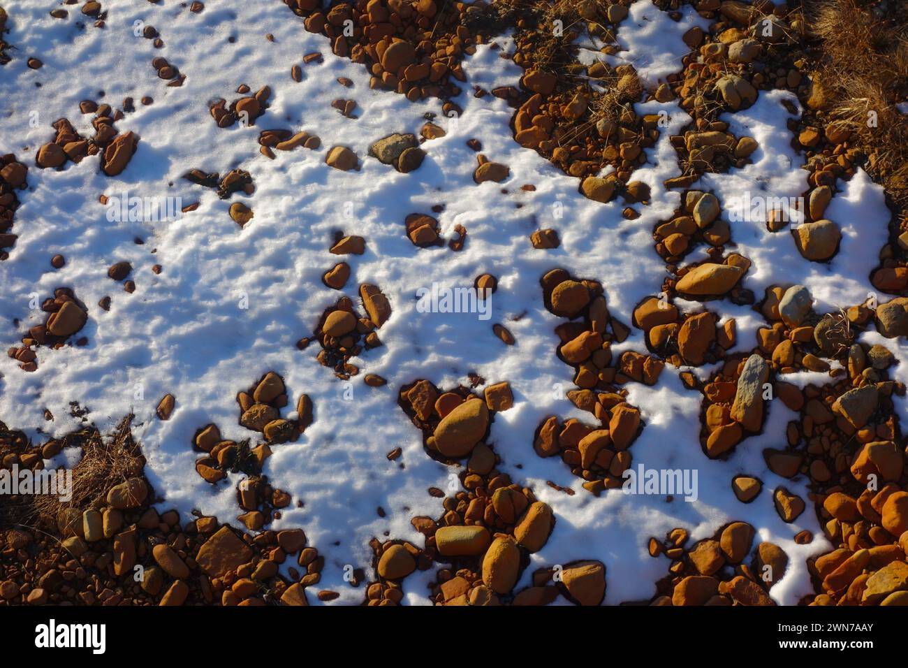 Melting snow and red rocks in riverbed, Gifu Prefecture, Honshu, Japan Stock Photo