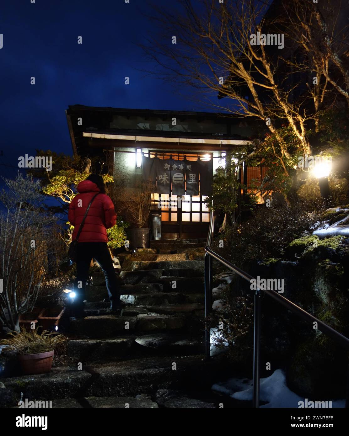 Person in red jacket entering traditional Izakaya restuarant, Lake Yamanaka, Mt Fuji region, Japan Stock Photo