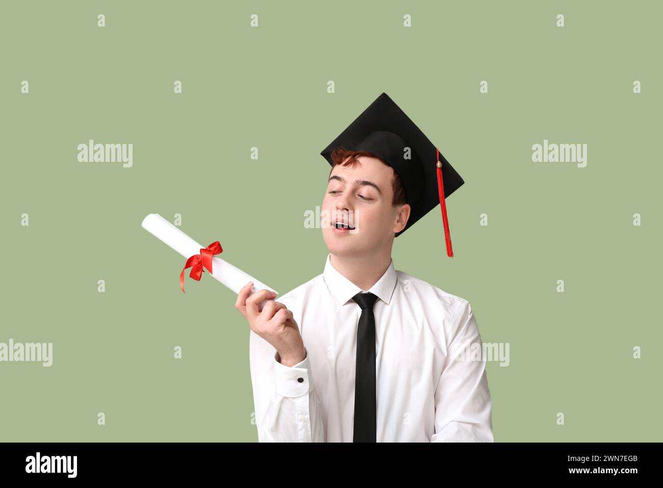Male student in mortar board with diploma on green background Stock ...