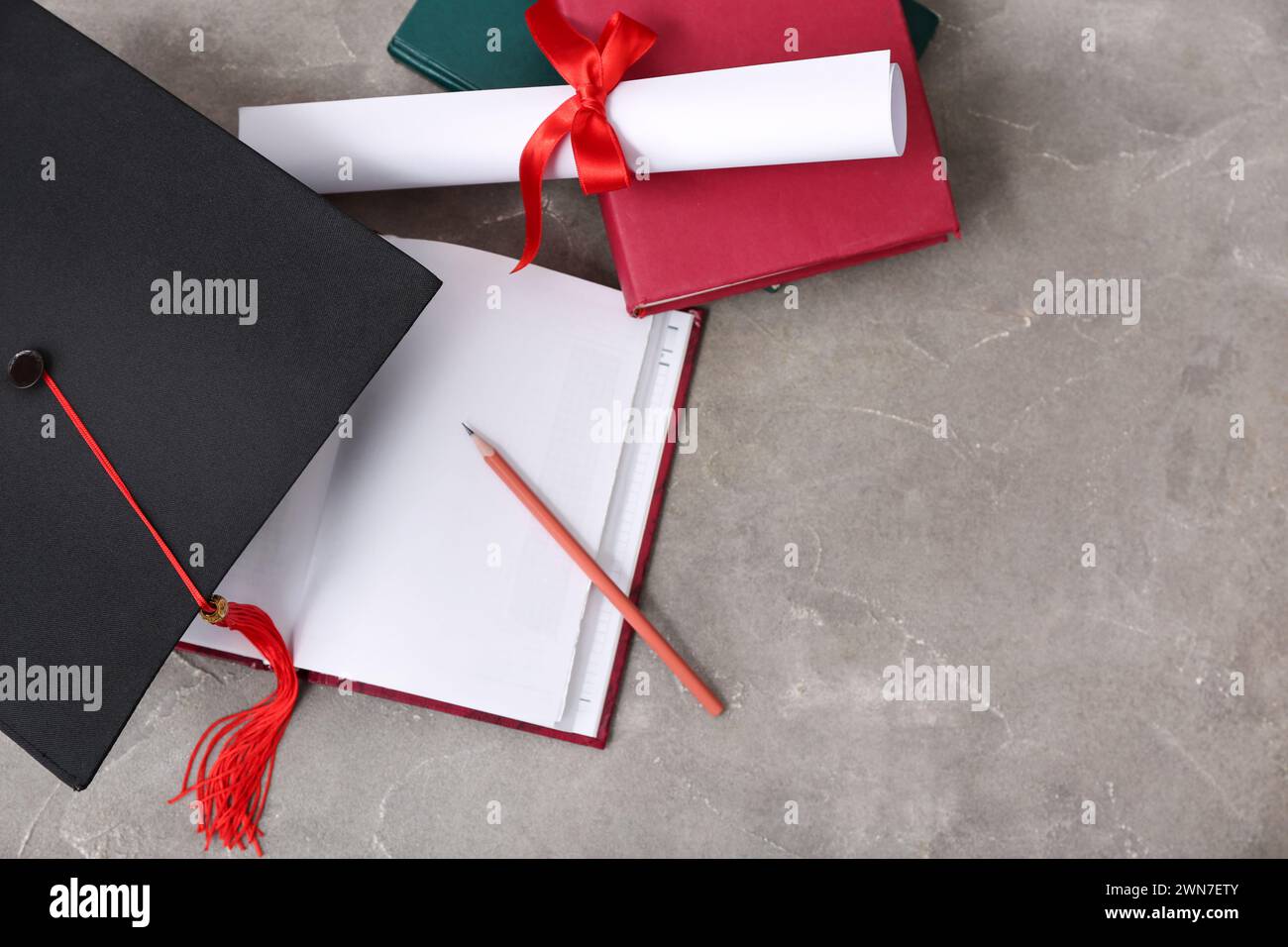 Mortar board with diploma and notebooks on grey background Stock Photo ...