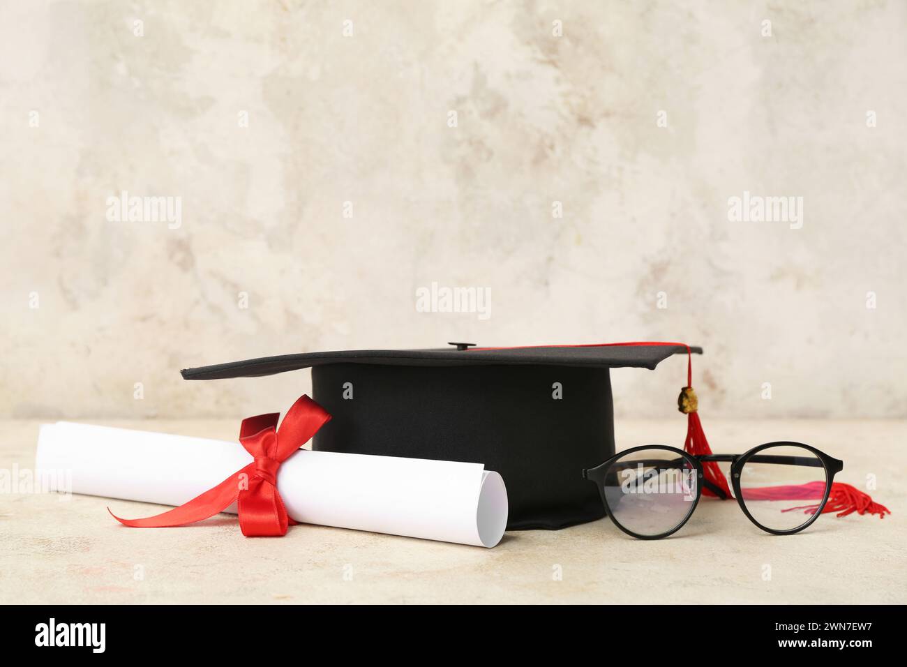 Mortar board with diploma and eyeglasses on beige background Stock ...