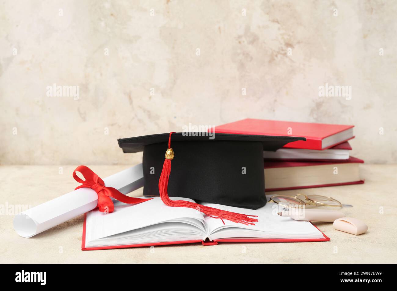 Mortar board with diploma, eyeglasses and notebooks on beige background ...