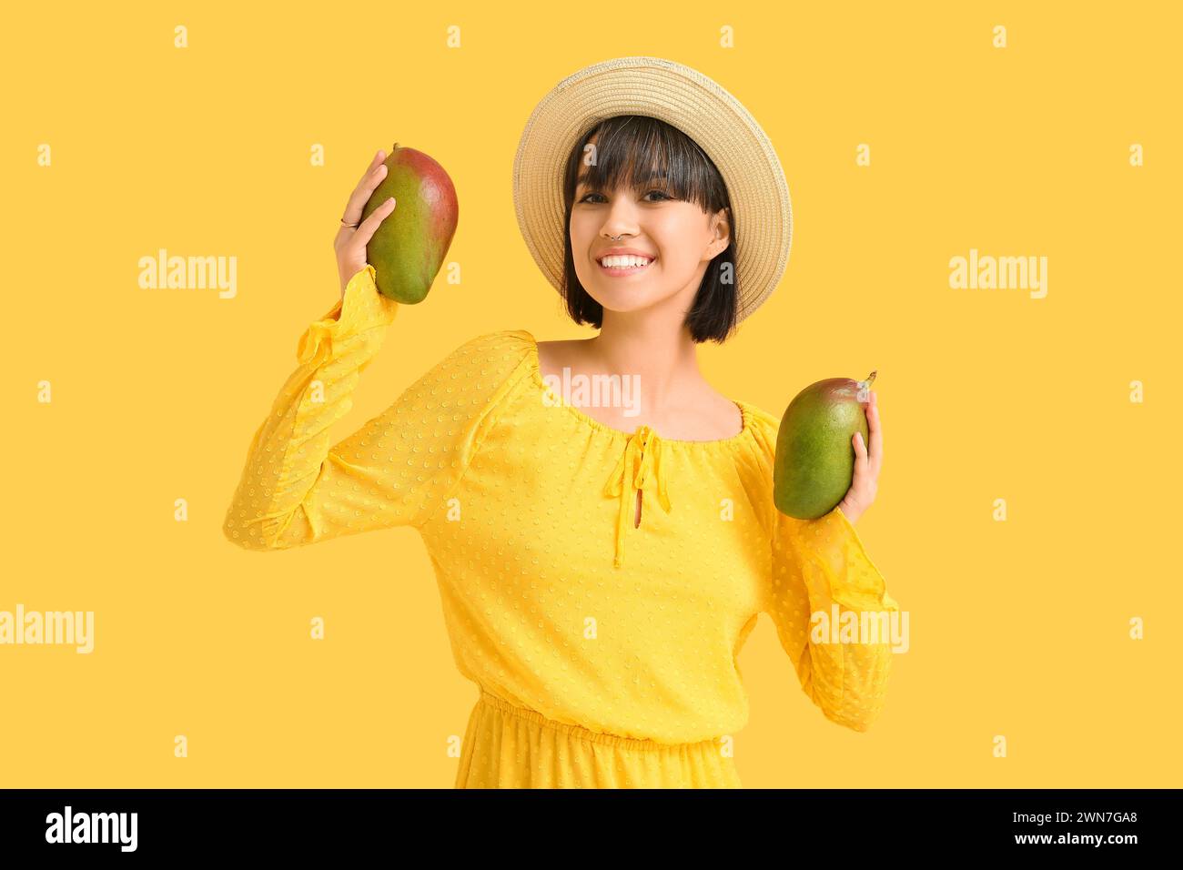 Beautiful young woman with ripe mangoes on yellow background Stock ...