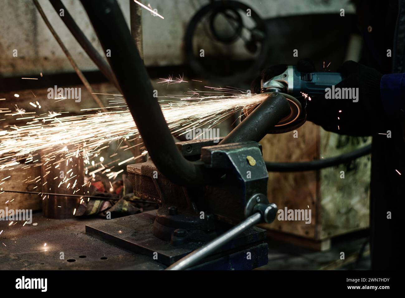 Closeup of unrecognizable man using angle grinder while doing metalwork, copy space Stock Photo