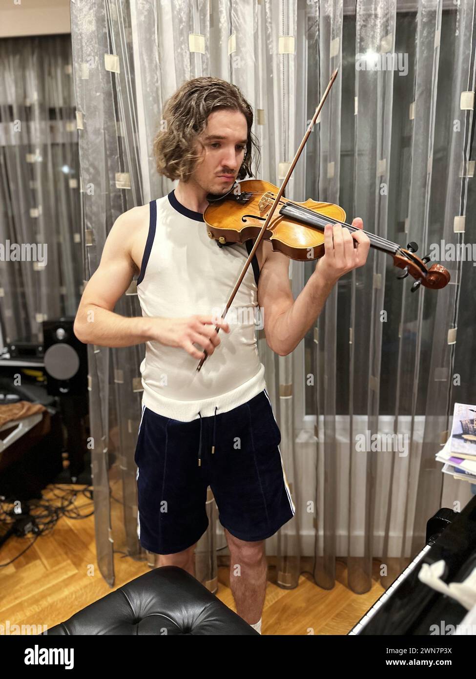 Young handsome man playing violin at home Stock Photo