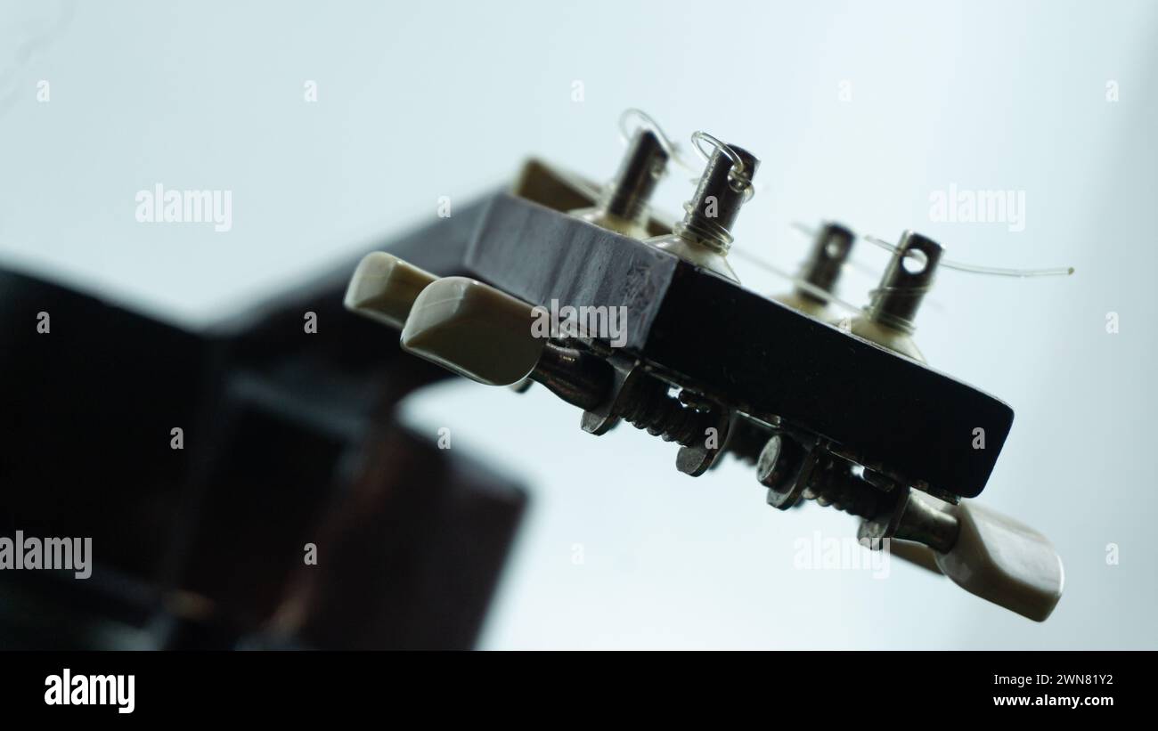 Ukulele head with 4 tuners and strings Stock Photo